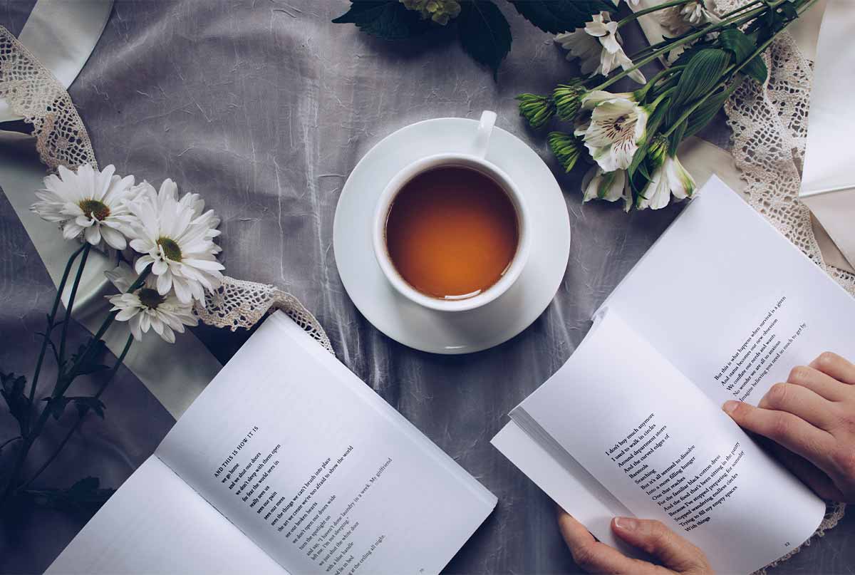 کتاب باز و فنجان قهوه و گل سفید