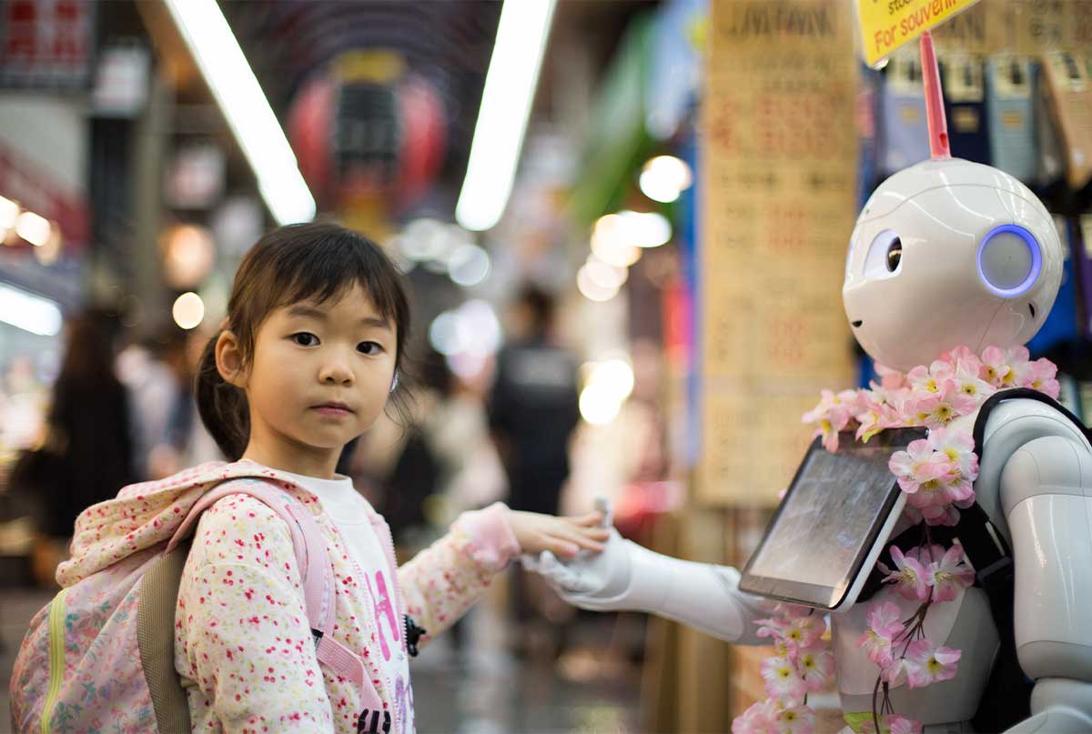 دختر بچه ای که به ربات دست داده
