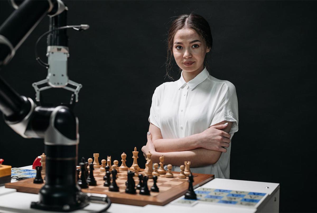 خانمی با پیراهن سفید پشت میز با شطرنج