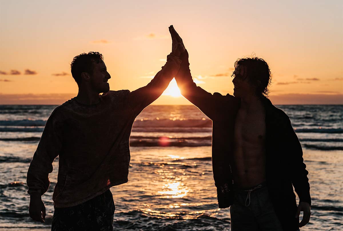دو تا پسر که کنار دریا دستاشون رو به هم زدن